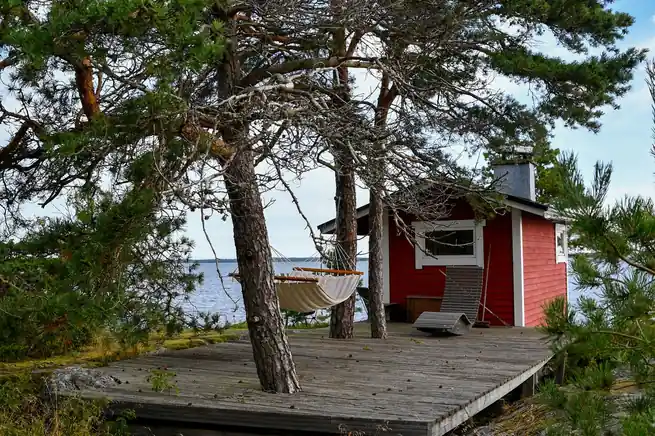 Puinen terassi ja rauhallinen rantasaunan terassimaisema mäntyjen siimeksessä